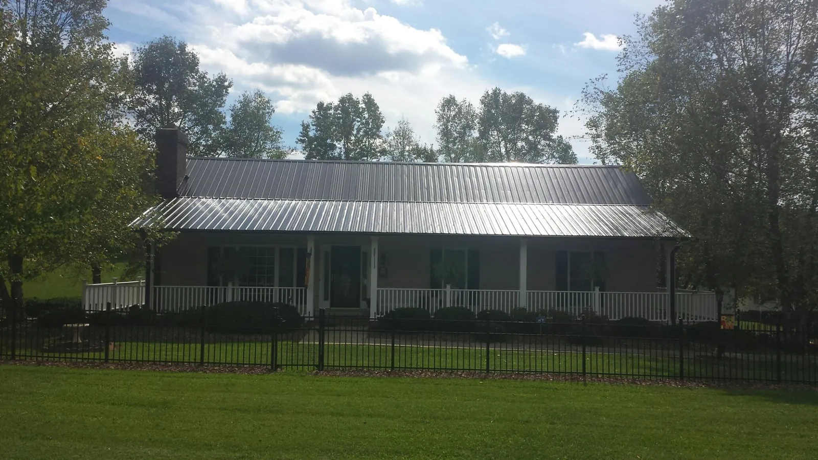 Gray metal roof on a brick ranch with a full width front porch — Gutter Guard Installation work by our crew in Pike Road