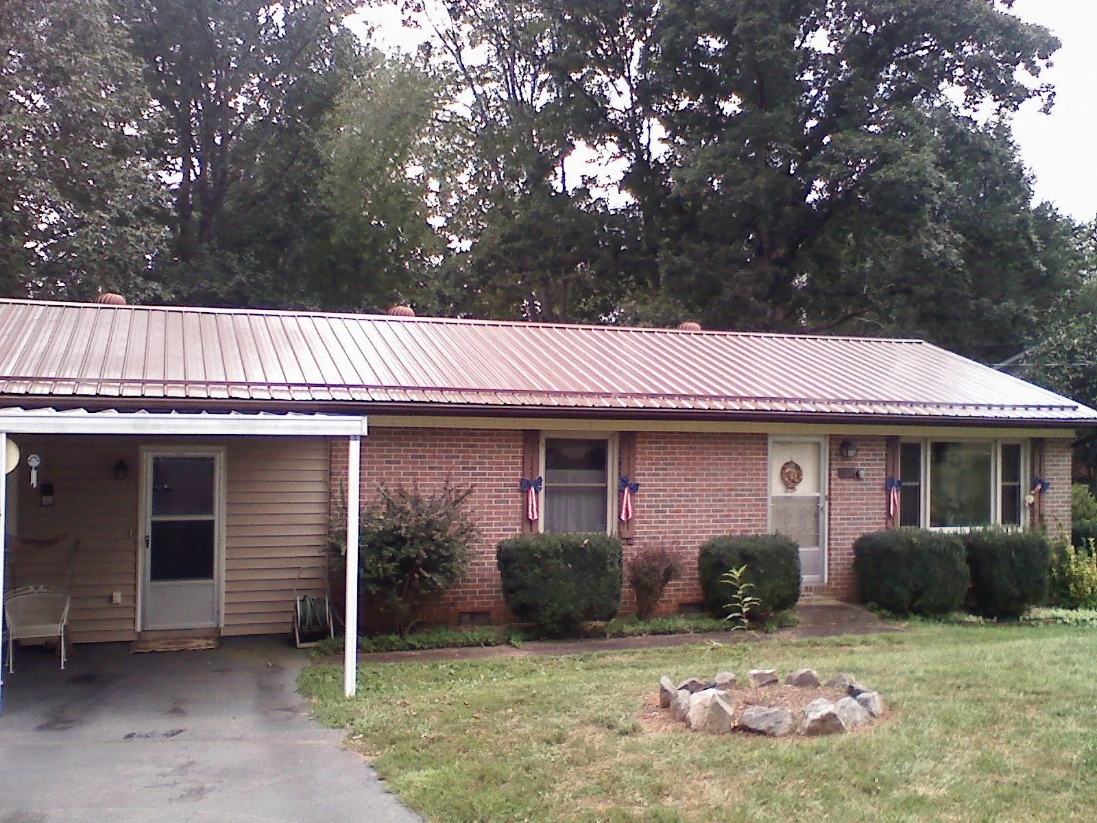 Bronze metal roof and carport on a brick ranch home — Roof Repair work by our crew in Pike Road